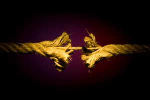 Frayed rope breaking on a dark background