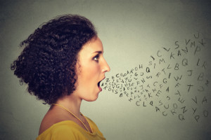 Woman talking with alphabet letters coming out of her mouth. Communication, information, intelligence concept